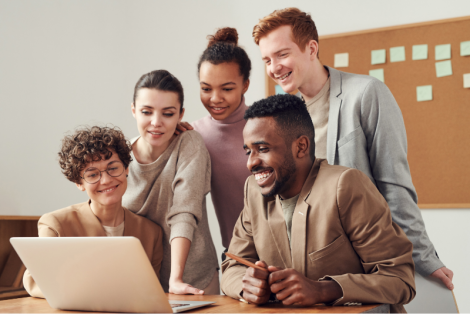 Multiple adults gathered around a laptop