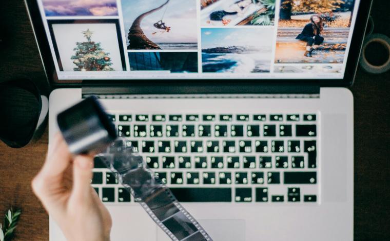 person in front of an open laptop rolling out film