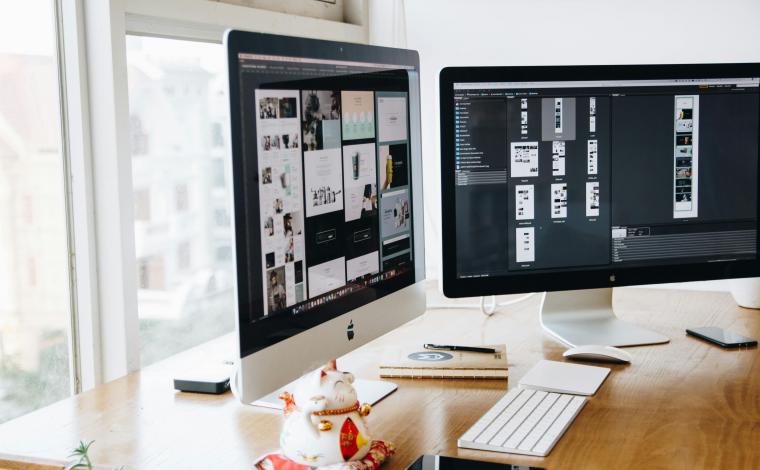 two macbooks on a desk displaying design elements