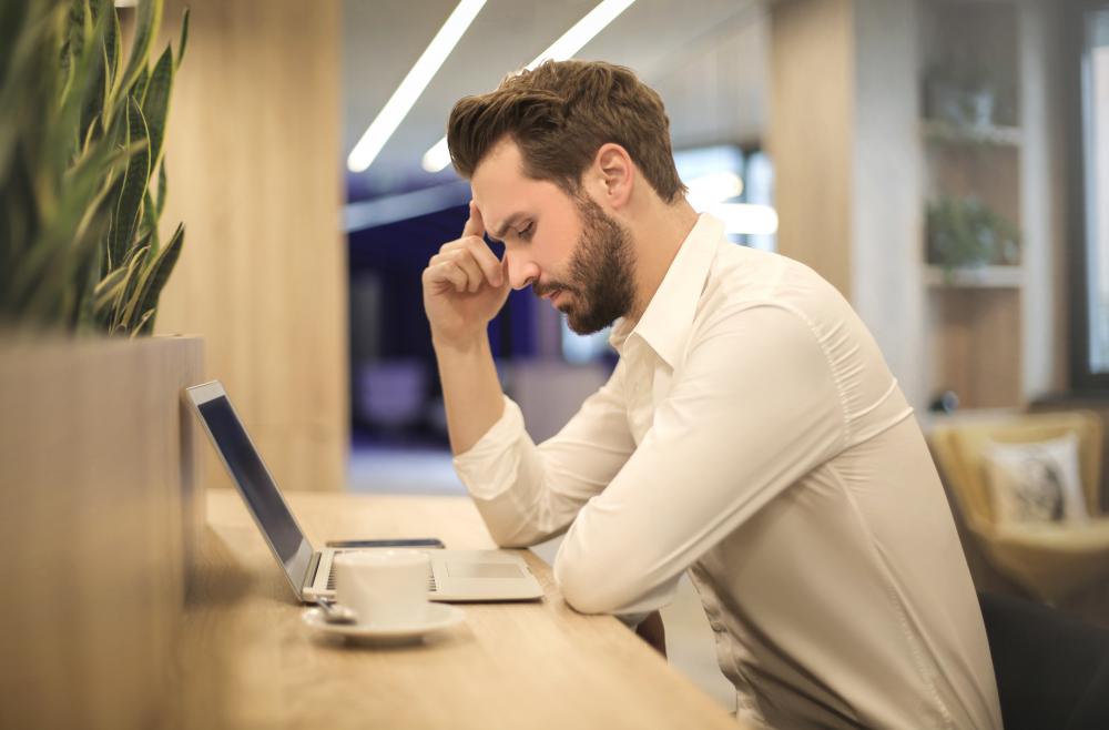 man looking at laptop looking upset