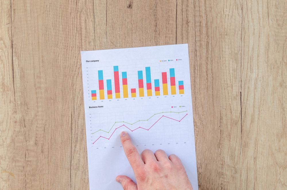 hand pointing at paper with statistics