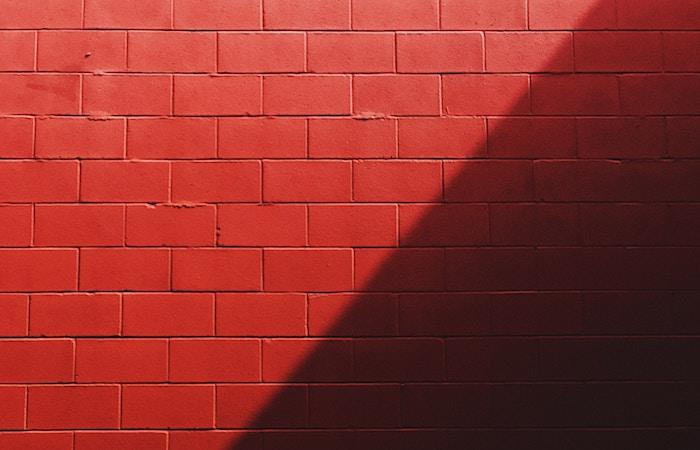 photo of a red brick wall that has the right half of the wall shadowed