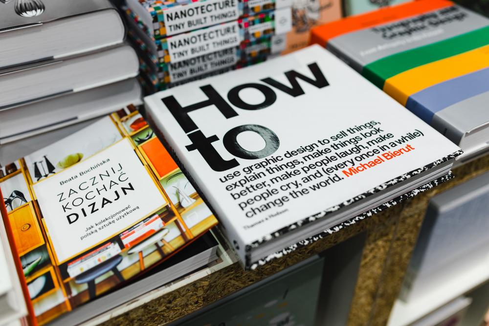 a stack of books and the main focus is a book that says "how to" in large text