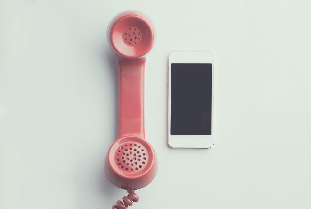 an old cord phone and an iphone next to each other