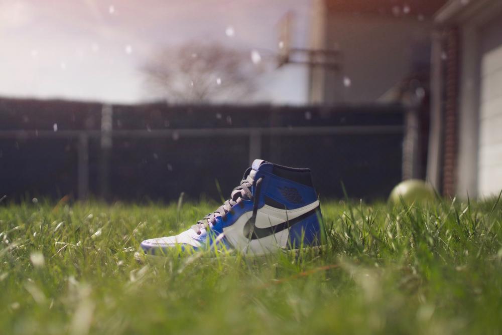 a blue nike shoe in a grass field