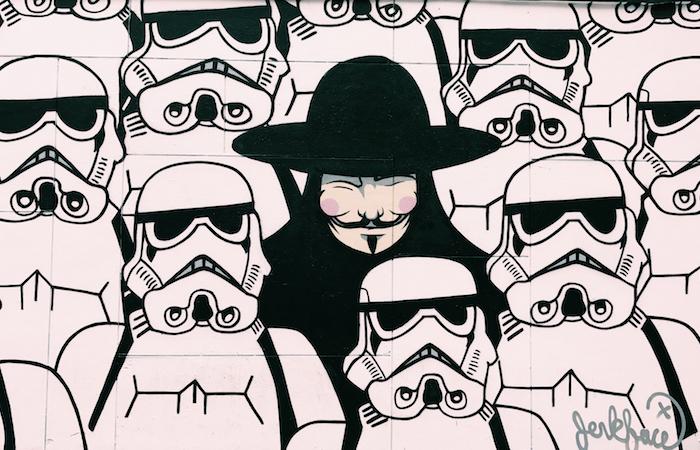 an art piece of the main character from v for vendetta in the middle of a fleet of storm troopers from star wars