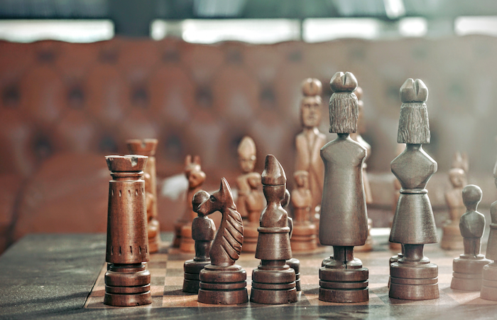 a chess board with wooden chess pieces on top of a table